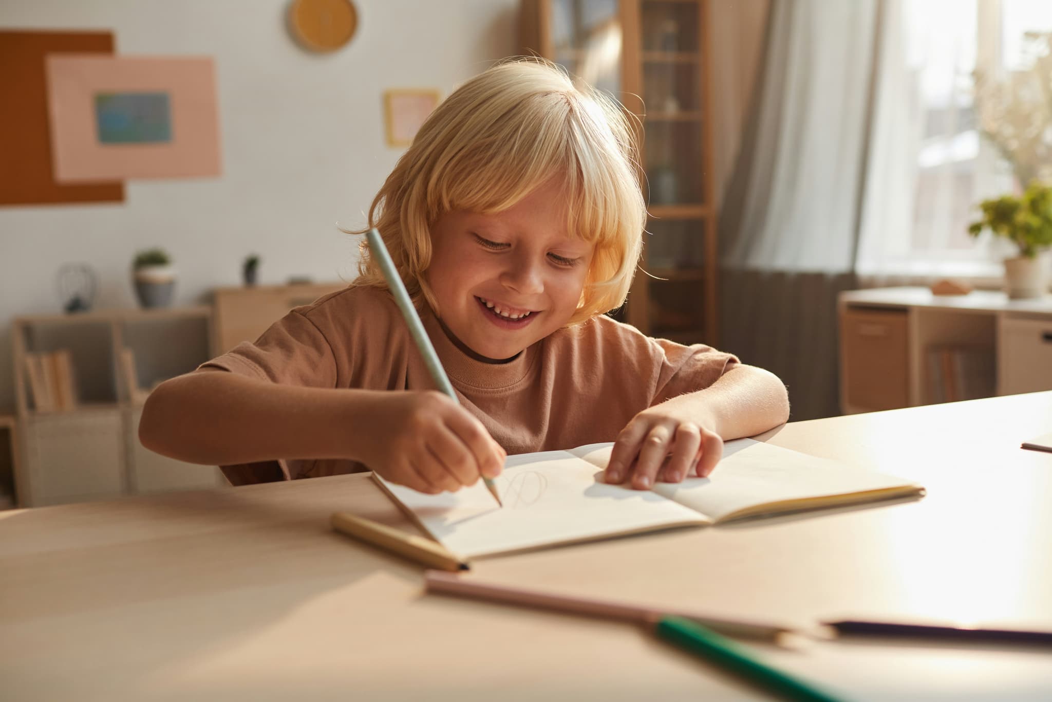Picture of a kid that is happily drawing doodles in an open book